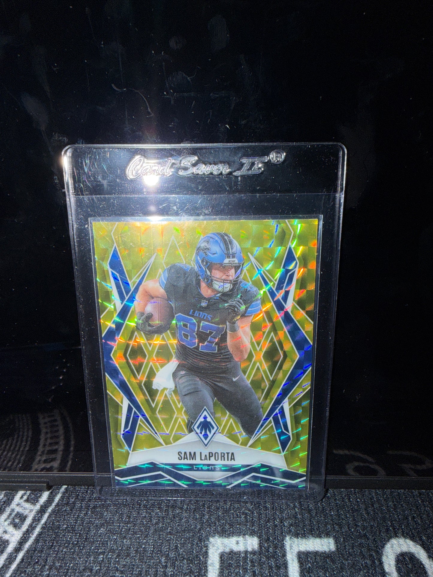 2025 Panini Phoenix Football Sam LaPorta – Yellow Pyramids parallel, serial numbered 004/185 (Card #44).