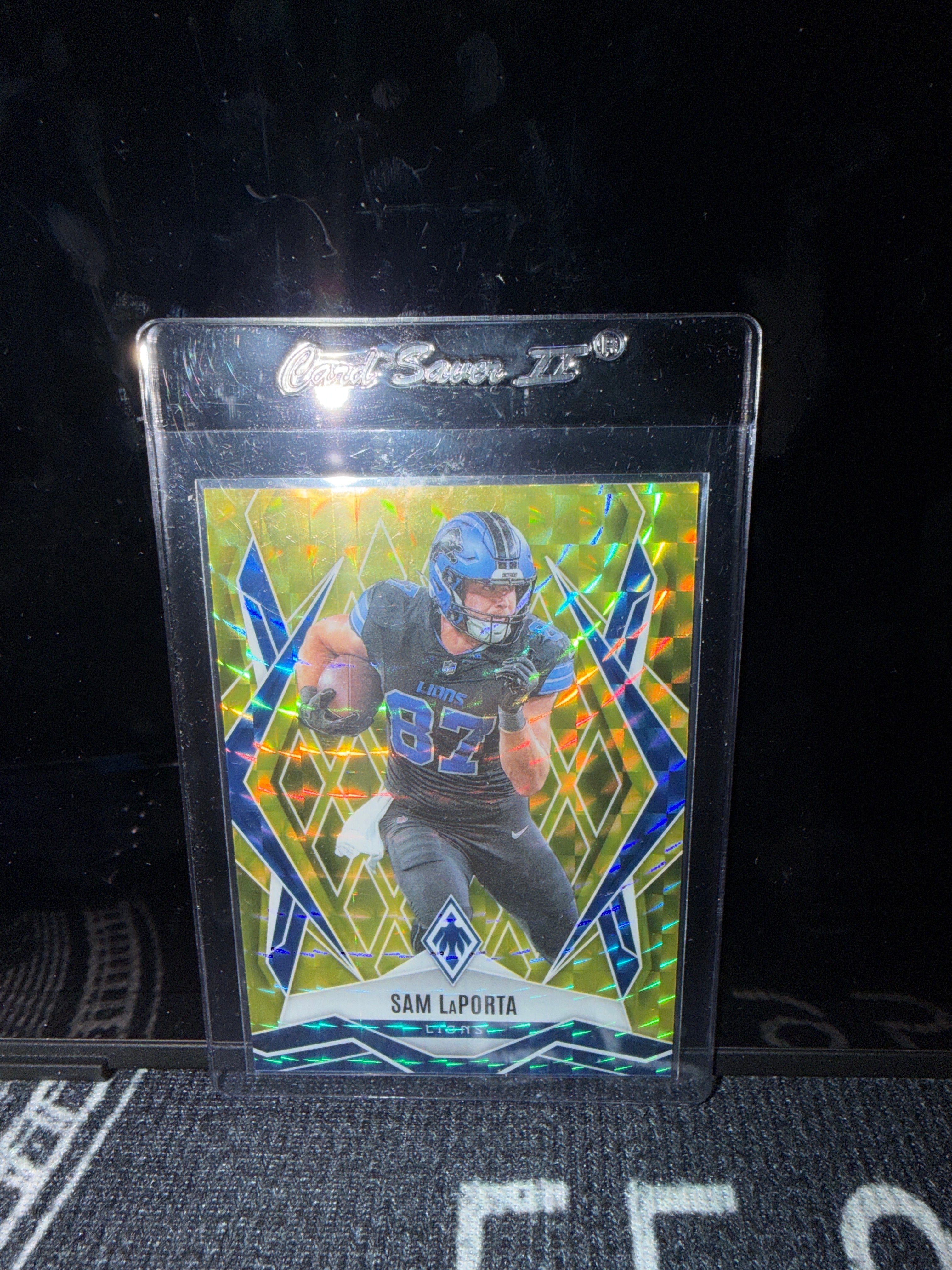 2025 Panini Phoenix Football Sam LaPorta – Yellow Pyramids parallel, serial numbered 004/185 (Card #44).