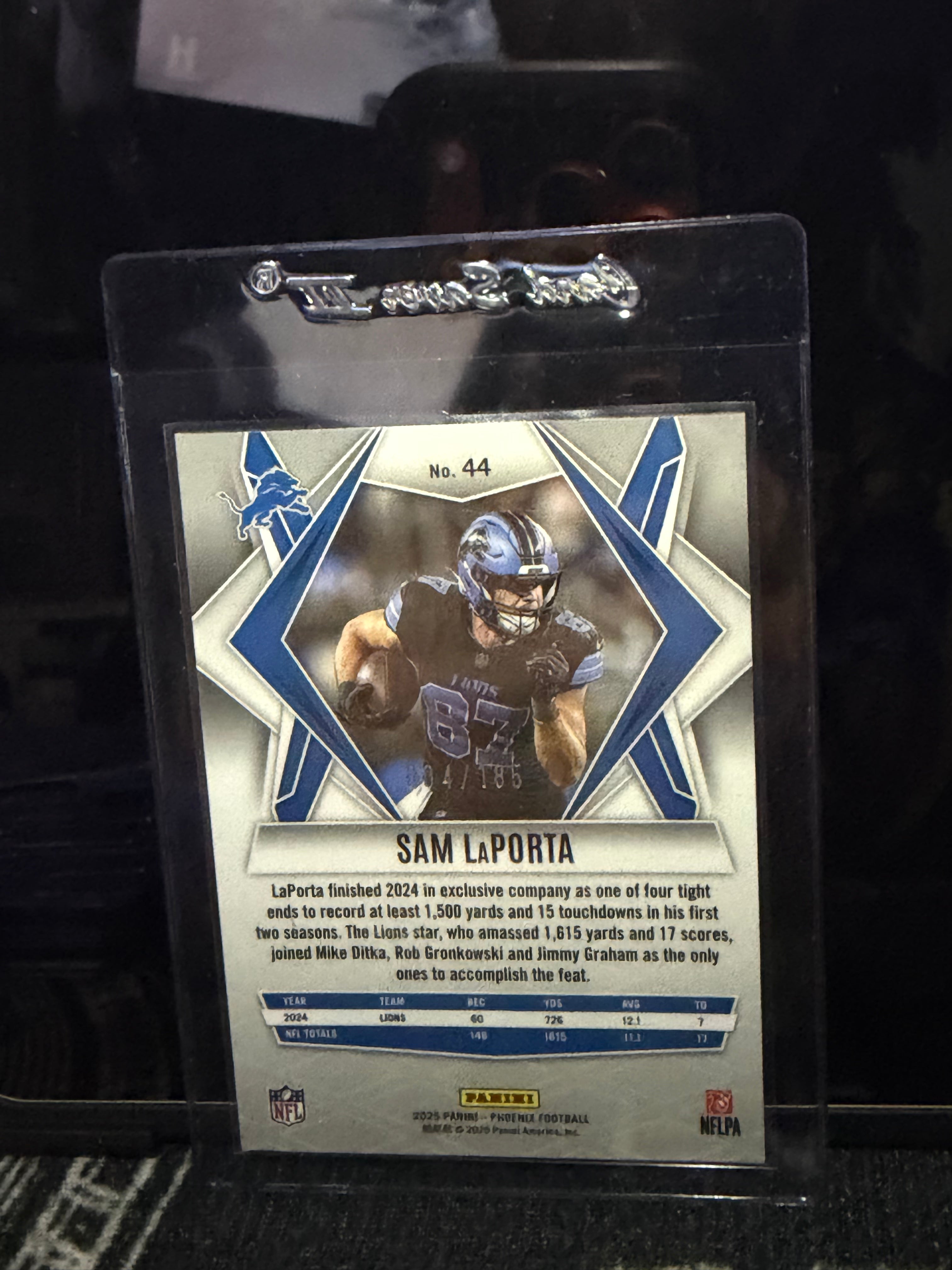 2025 Panini Phoenix Football Sam LaPorta – Yellow Pyramids parallel, serial numbered 004/185 (Card #44).