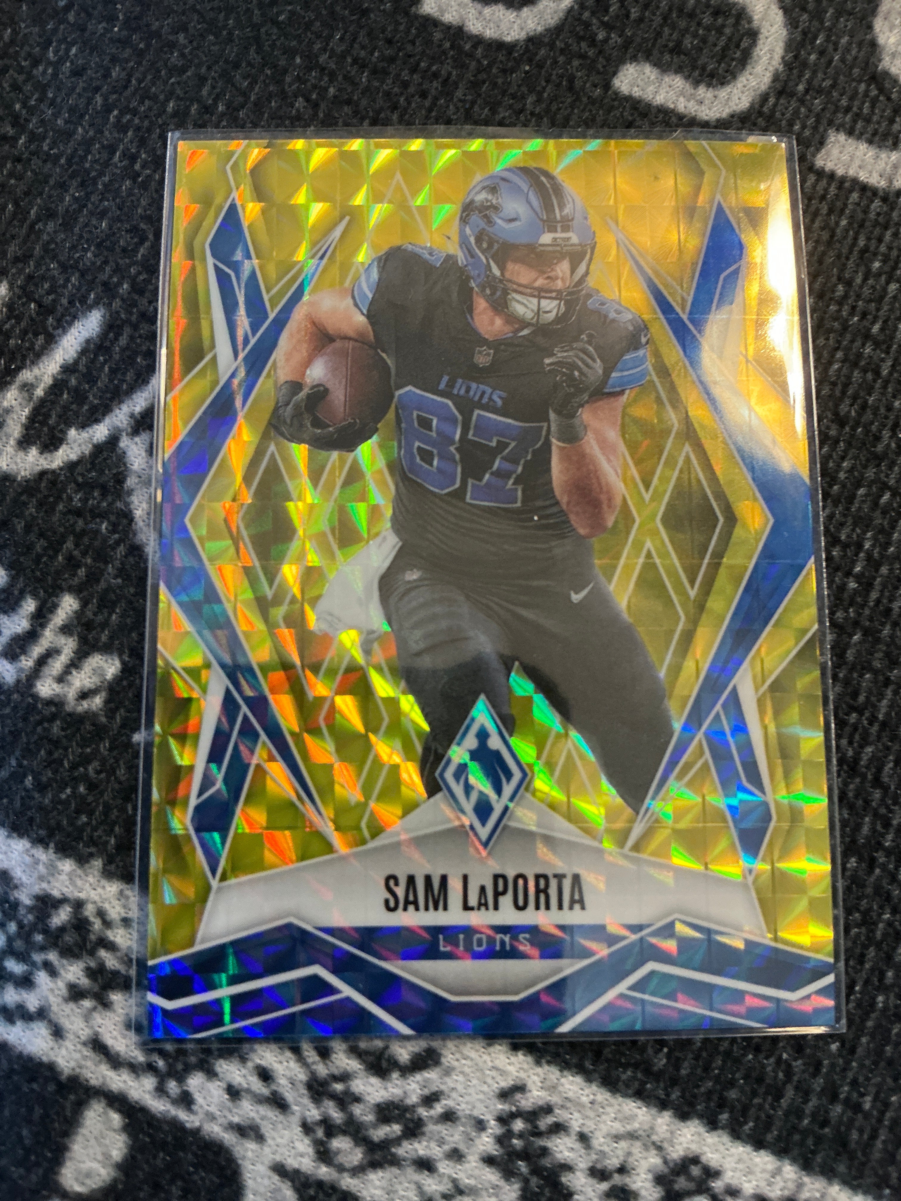 2025 Panini Phoenix Football Sam LaPorta – Yellow Pyramids parallel, serial numbered 004/185 (Card #44).